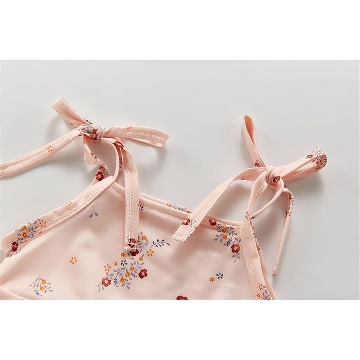 Gros plan d'un tissu rose pâle froissé avec un motif floral délicat. Idéal pour la couture, l'artisanat ou la décoration.