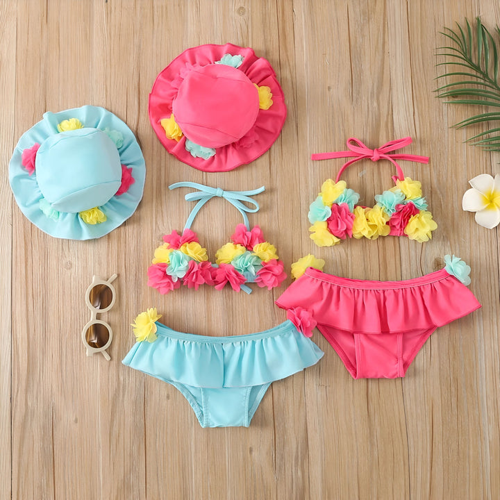 Ensemble de bain rose pour enfant avec fleurs décoratives : haut de bikini à nouer, culotte à volants et chapeau assorti. Vêtements de plage pour filles, mode été, protection solaire.