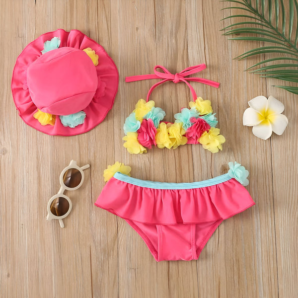 Haut de bikini rose pour enfant, orné de fleurs colorées en tissu. Accessoire de mode estivale pour filles, idéal pour la plage et la piscine.