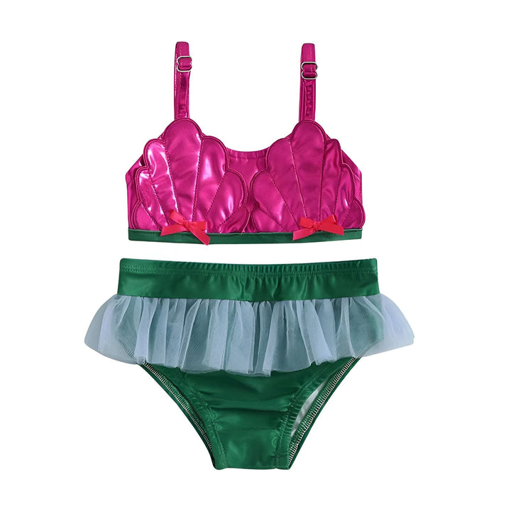 Ensemble de maillot de bain pour enfant. Le haut est rose scintillant avec des bretelles, et le bas est vert foncé avec une bordure en tulle bleu clair. Il y a aussi des décorations de coquillages et une pastèque.