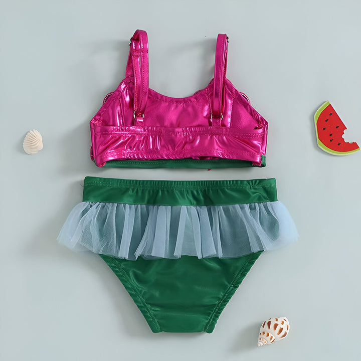 Maillot de bain enfant inspiré de la Petite Sirène. Haut de bikini rose en forme de coquillages avec nœuds rouges, et bas de bikini vert avec volants en tulle bleu clair. Costume de bain fantaisie pour fille.
