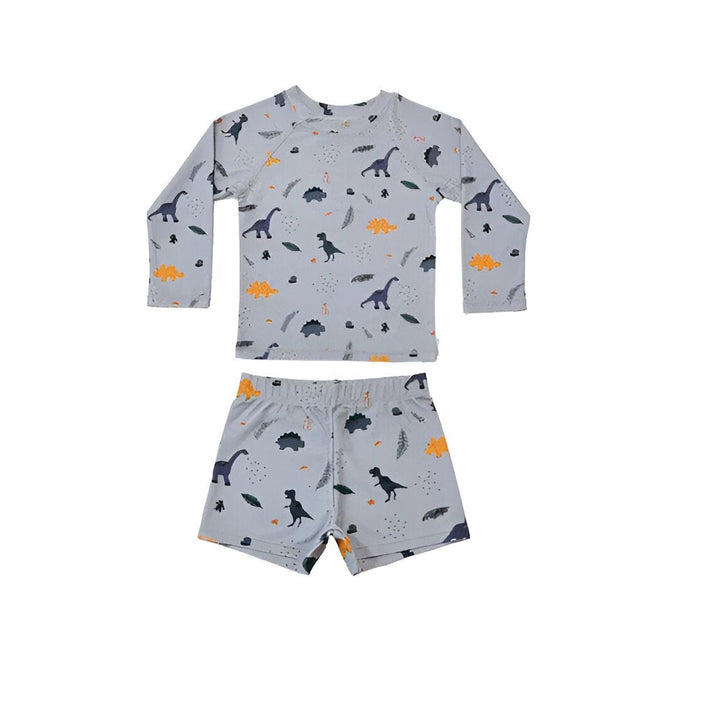 Ensemble de plage pour enfant, comprenant un t-shirt anti-UV à manches longues et un short assorti, tous deux à motifs géométriques colorés. Des lunettes de soleil rondes et des sandales Mini Melissa noires complètent le look. Idéal pour les vacances d'été des petits.