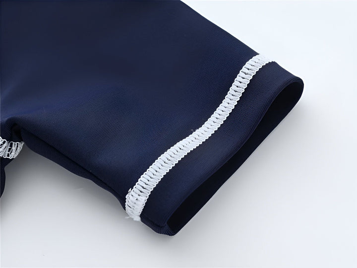 Gros plan sur la manche d'un vêtement bleu marine avec une bordure décorative blanche. Détails du tissu et de la finition. Style classique et élégant. Idéal pour la mode et le design.