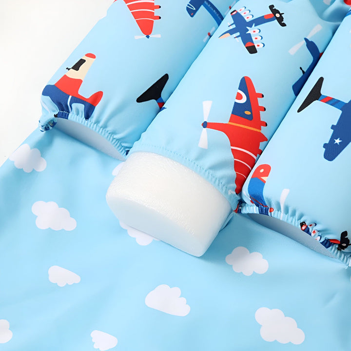 Gros plan d'un tissu bleu ciel imprimé de nuages blancs. Détail de couture visible. Idéal pour vêtements d'été, accessoires enfants, ou décoration à thème céleste.