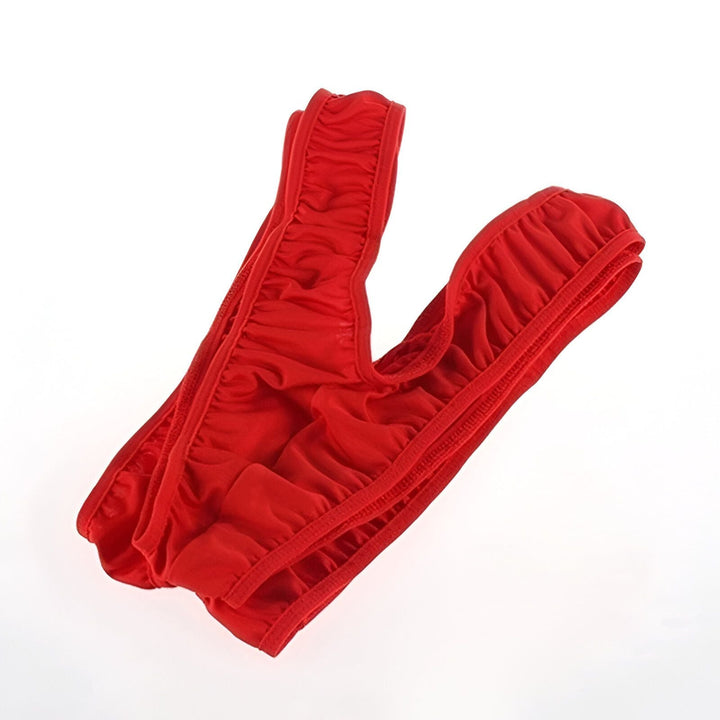 Homme musclé en string vert fluo, bandeau et bracelets assortis. Déguisement humoristique des années 80, pose expressive avec les bras levés. Costume de fête, tenue de sport parodique.