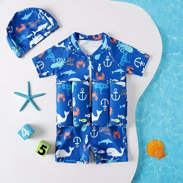 Maillot de bain flottant pour enfants avec motifs marins bleus et blancs. Il est accompagné d'un bonnet de bain assorti, parfait pour les premières baignades en toute sécurité.