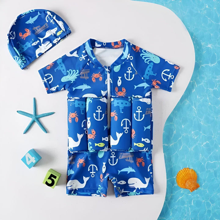 Maillot de bain flottant pour enfants avec motifs marins bleus et blancs. Il est accompagné d'un bonnet de bain assorti, parfait pour les premières baignades en toute sécurité.