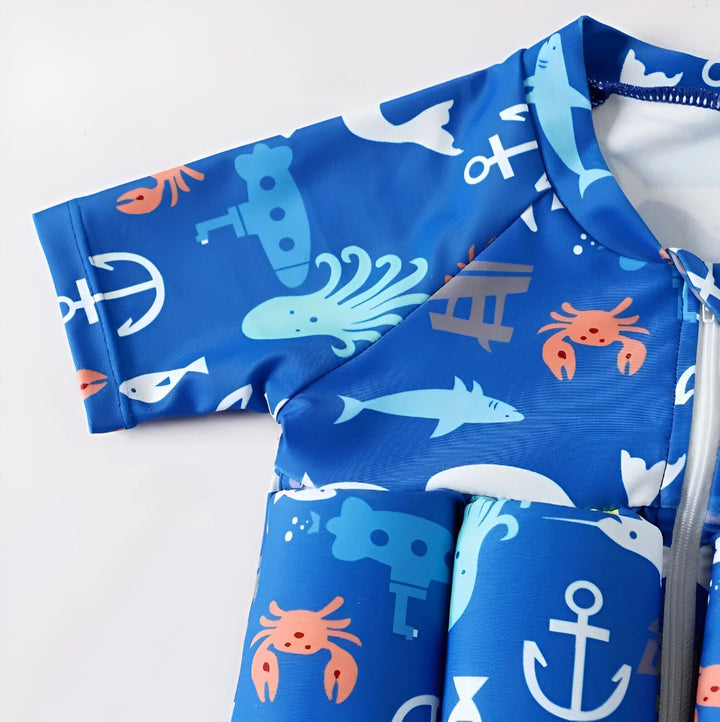 Combinaison de bain flottante bleue pour enfant, motif marin (ancre, crabe, requin, sous-marin, pieuvre). Fermeture éclair sur le devant. Idéale pour apprendre à nager en toute sécurité.