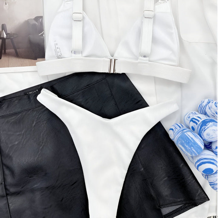 Femme en bikini bleu avec blazer blanc, mode estivale. Maillot de bain tendance, style de plage élégant. Détails dorés sur les bretelles et la culotte. Accessoire de mode, vêtements de vacances.