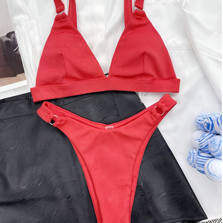 Ensemble de bikini noir côtelé sur une chemise blanche, avec des détails de boules décoratives bleues et blanches. Maillot de bain deux pièces moderne et élégant.