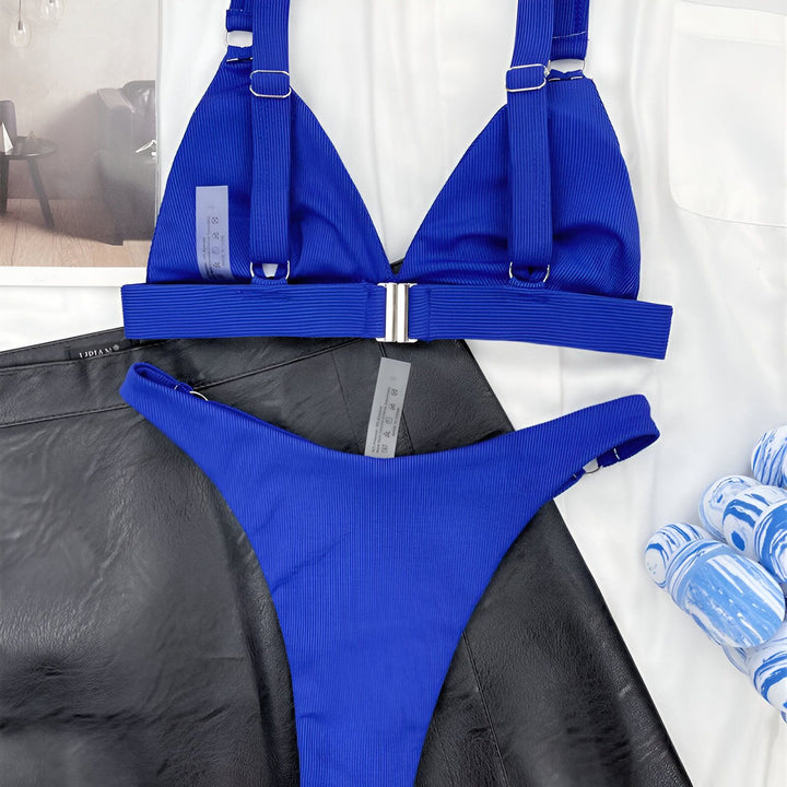 Image d'une femme portant un bikini blanc texturé et un blazer blanc. Mode estivale élégante, tenues de plage tendance.