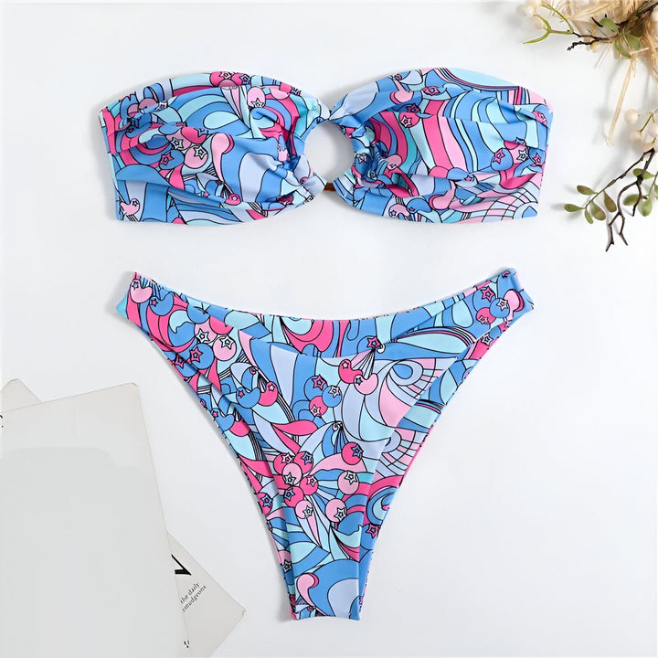 Ensemble de bikini à motif abstrait bleu, rose et blanc, comprenant un haut bandeau torsadé et une culotte assortie. Idéal pour la plage ou la piscine, style moderne et coloré.
