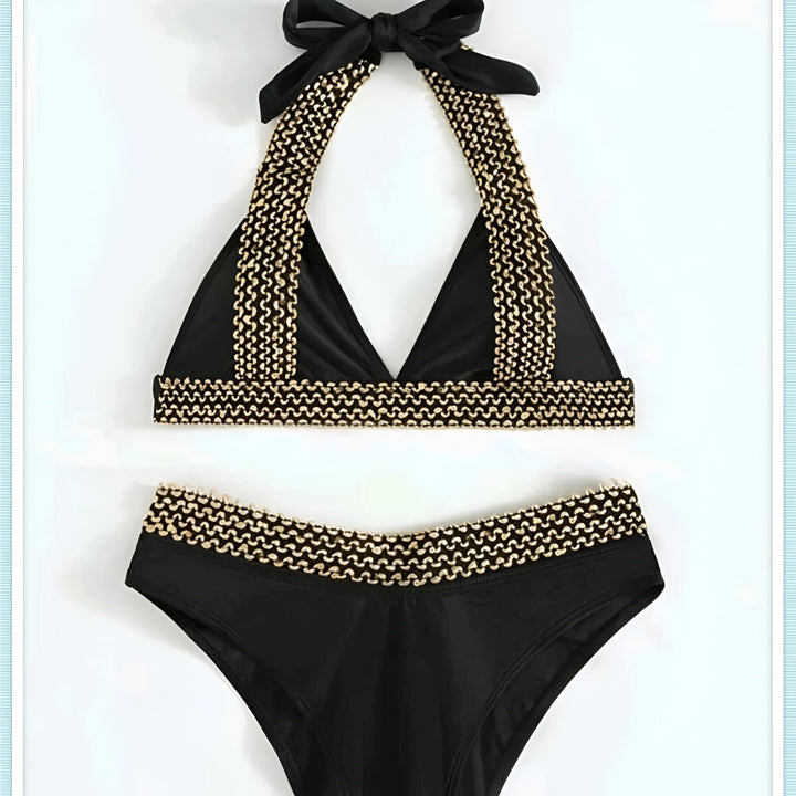 Image d'un ensemble de bikini noir avec détails dorés, chapeau de paille, lunettes de soleil et sac de plage. Idéal pour un look estival élégant.