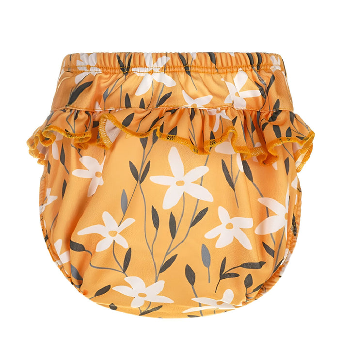 Gros plan sur un bloomers rose à motifs floraux blancs avec volants, élastique à la taille. Idéal pour les bébés et jeunes enfants.