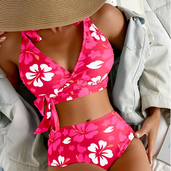 Image d'un bikini orange à motifs floraux, accompagné de lunettes de soleil en forme de cœur et d'un chapeau de paille, évoquant l'été et les vacances.