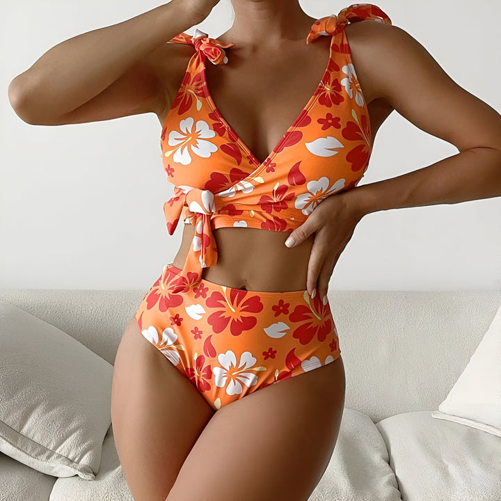 Ensemble de bikini violet à fleurs, haut à nouer au cou, bas taille haute assorti. Imprimé floral violet et blanc sur fond clair. Idéal pour la plage et la piscine.