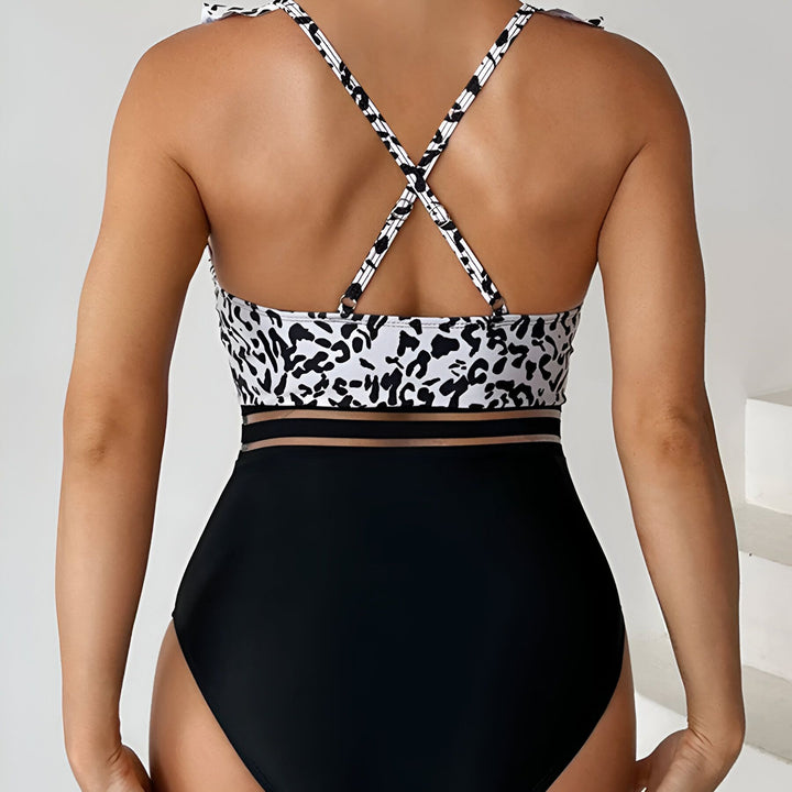 Maillot de bain une pièce pour femme, haut à motif léopard avec volants, bas noir uni, style tendance et féminin. Idéal pour la plage ou la piscine.