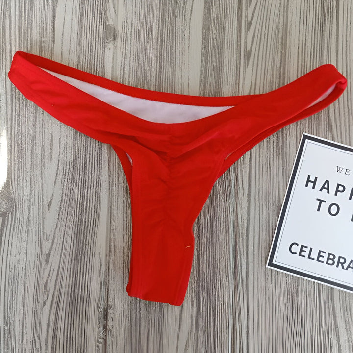 Culotte de bikini orange vif sur fond bois avec carte Brooklyn. Sous-vêtement de plage tendance.