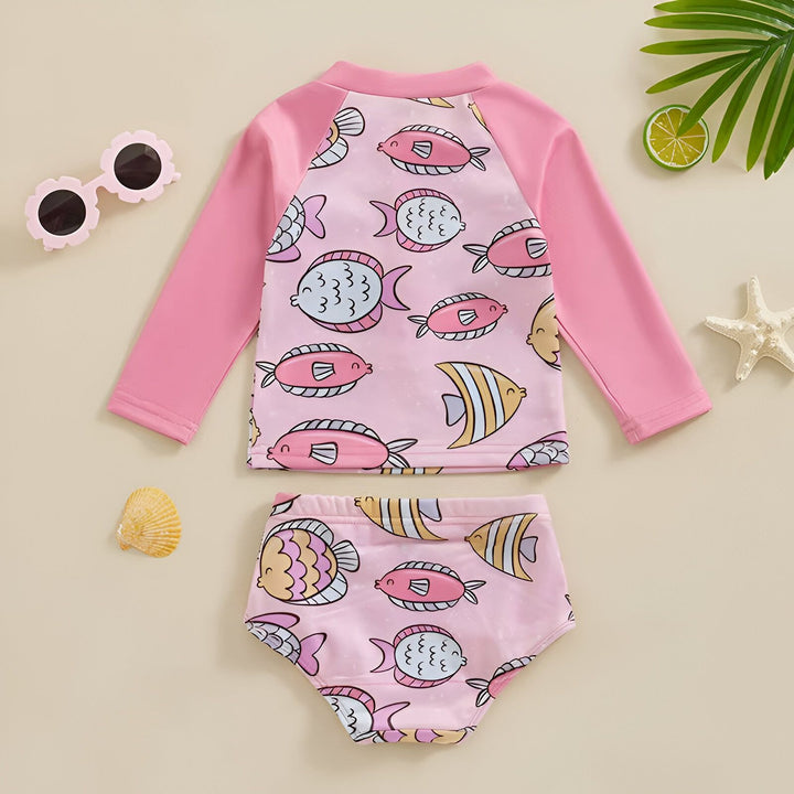 Ensemble de bain rose pour bébé fille avec motif de poissons. Haut à manches longues et bas assorti, lunettes de soleil, coquillage, étoile de mer et citron vert. Tenue de plage estivale pour enfant.