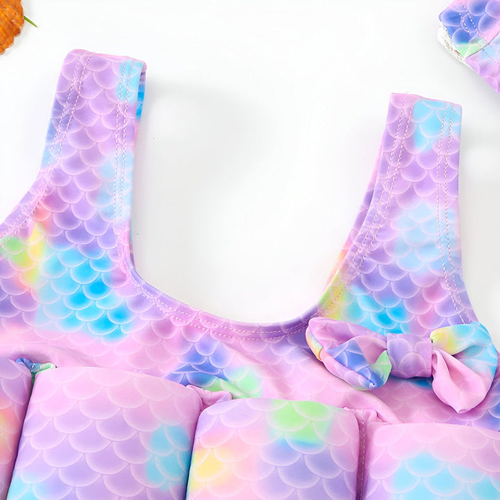 Coussin pour enfant avec motif écailles de sirène aux couleurs pastel (violet, rose, bleu). Détail de la mousse de rembourrage. Accessoire décoratif pour chambre d'enfant.