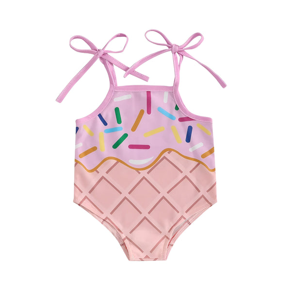 Maillot de bain bébé rose imprimé glace avec bretelles à nouer. Motifs de vermicelles colorés et gauffre. Décorations estivales : citron, pastèque et mini glace. Vêtement de plage tendance pour enfant.