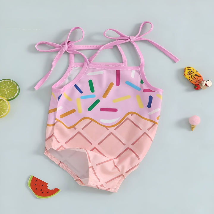 Maillot de bain une pièce rose pour bébé avec motif de cornet de glace et bretelles à nouer. Idéal pour la piscine et les vacances d'été. Vêtement de bain mignon et tendance pour enfants.