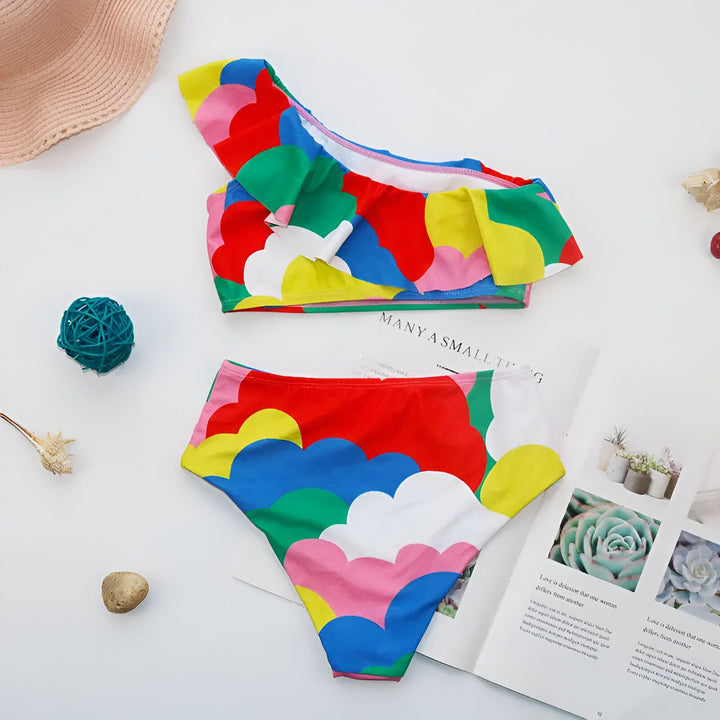 Gros plan sur le tissu d'un vêtement aux couleurs vives (vert, rose, rouge, jaune, bleu et blanc). Détail de la doublure blanche en maille et des coutures. Texture et design coloré mis en évidence.