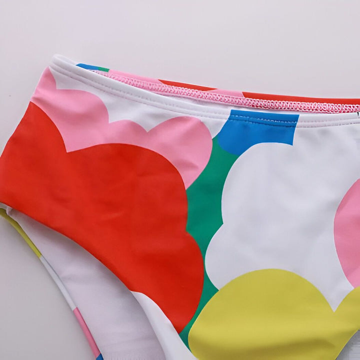 Ensemble de bikini multicolore à imprimé floral. Haut asymétrique à une épaule avec volants. Culotte de bain taille haute. Mode d'été, vêtements de plage.