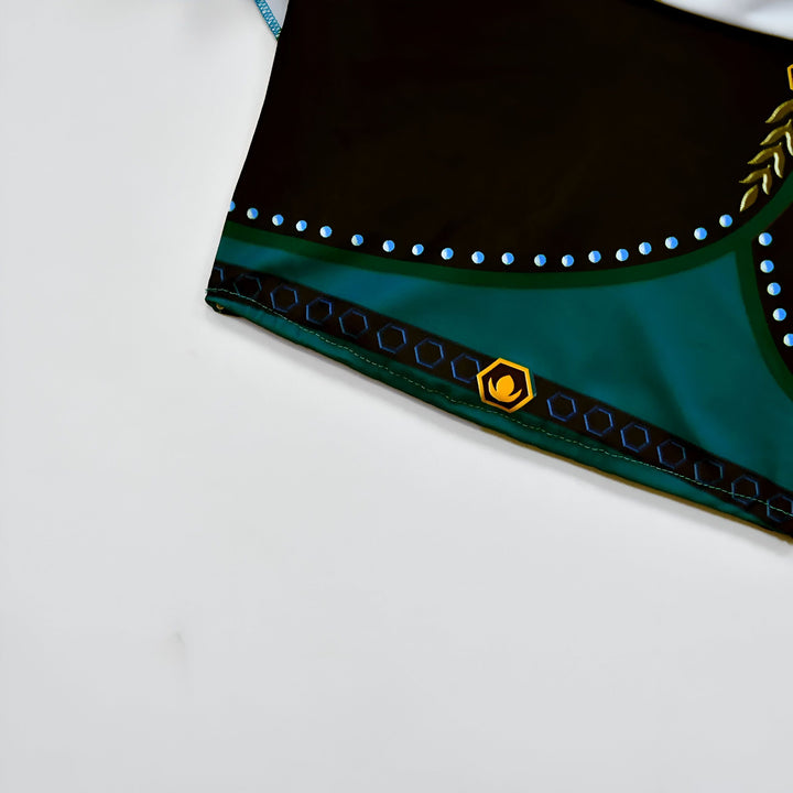 Ensemble deux pièces vert émeraude pour fille : haut à volants et jupe avec nœud décoratif. Style inspiré de la royauté, parfait pour les occasions spéciales.