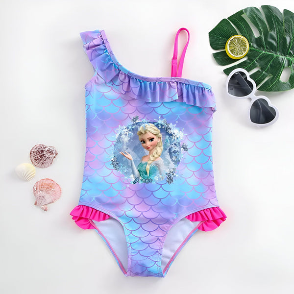 Maillot de bain une pièce pour enfant avec motif écailles de sirène, volant et bretelle rose. Lunettes de soleil en forme de cœur, feuille de palmier, citron coupé et coquillages. Thème estival et aquatique.