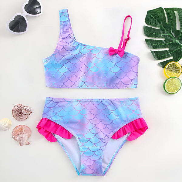 Gros plan sur un tissu bleu et violet à motif d'écailles de sirène. Texture douce et couleurs pastel. Idéal pour la mode et le design.