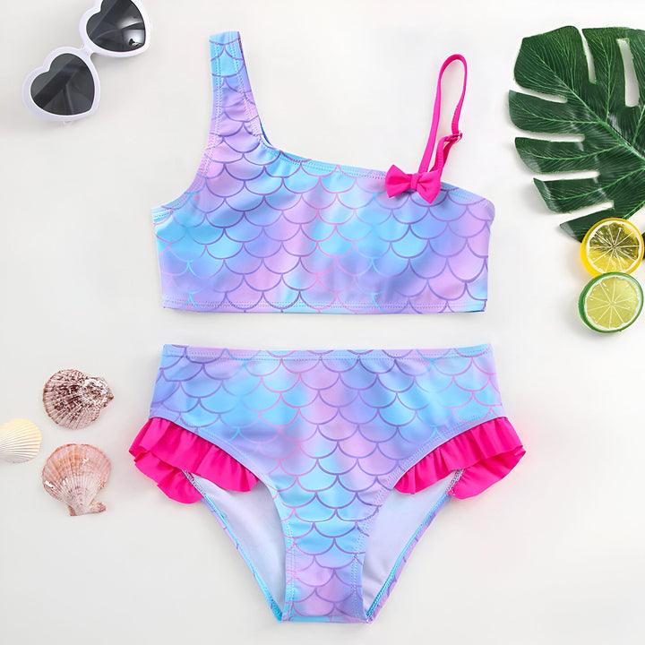 Gros plan sur un tissu bleu et violet à motif d'écailles de sirène. Texture douce et couleurs pastel. Idéal pour la mode et le design.