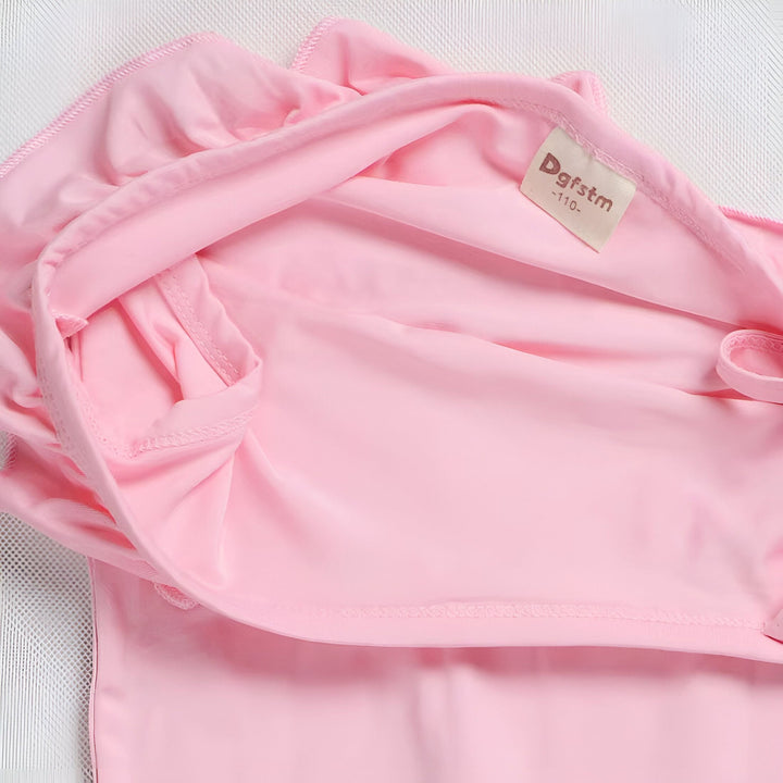 Vue rapprochée d'un vêtement rose pour enfant, marque Dgfstm, taille 110, sur un fond blanc. Tissu lisse et doux. Idéal pour la mode enfantine.