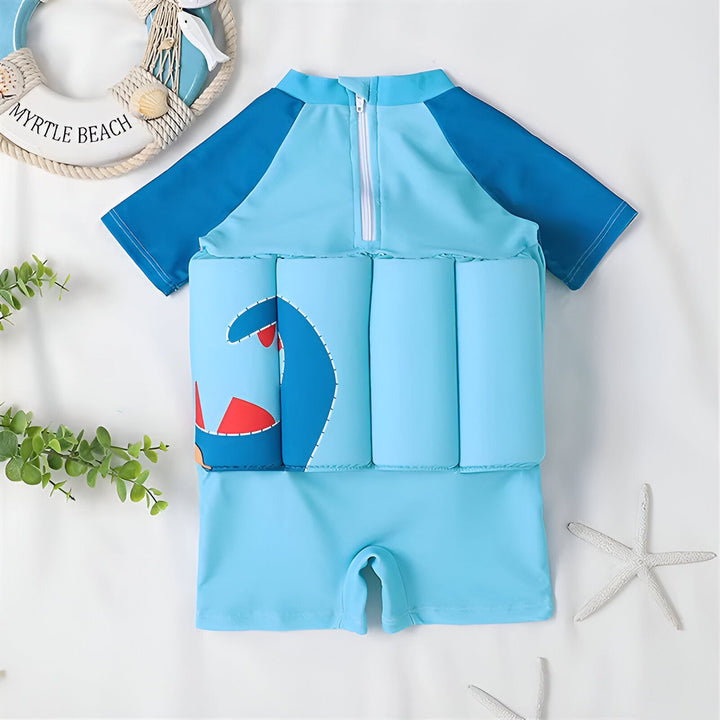 Maillot de bain flottant bleu pour enfants avec motif dinosaure et bouées intégrées. Vêtement de bain idéal pour apprendre à nager en toute sécurité.