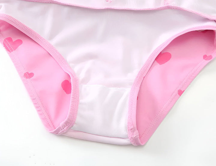 Maillot de bain flottant rose pour enfant, motif licorne ailée et coeurs. Comprend un bonnet de bain assorti avec illustration de pégase. Idéal pour l'apprentissage de la natation en toute sécurité.