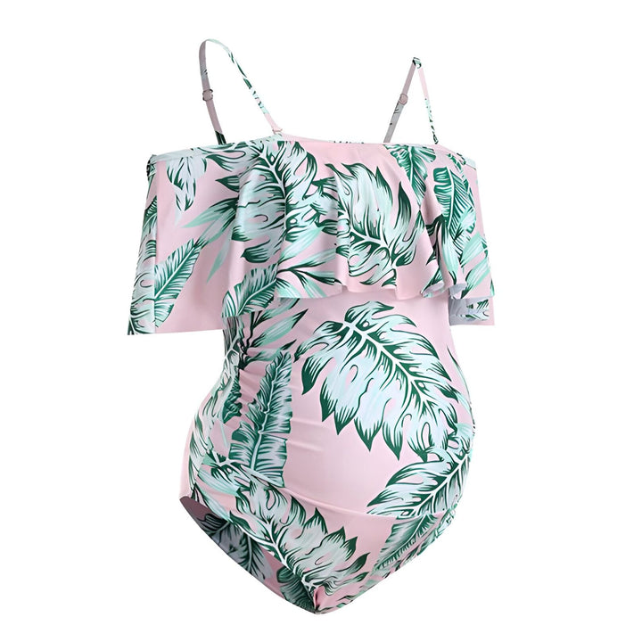 Maillot de bain de maternité rose avec motif de feuilles tropicales vertes et blanches. Bretelles fines et volants au niveau de la poitrine. Idéal pour la grossesse, le style et le confort à la plage.