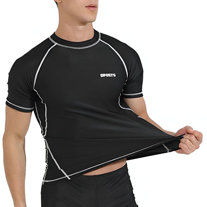 Un homme portant un t-shirt de sport noir moulant avec bordure blanche et le mot "SPORTS" imprimé, montrant l'extensibilité du tissu. Idéal pour l'entraînement et les activités sportives.