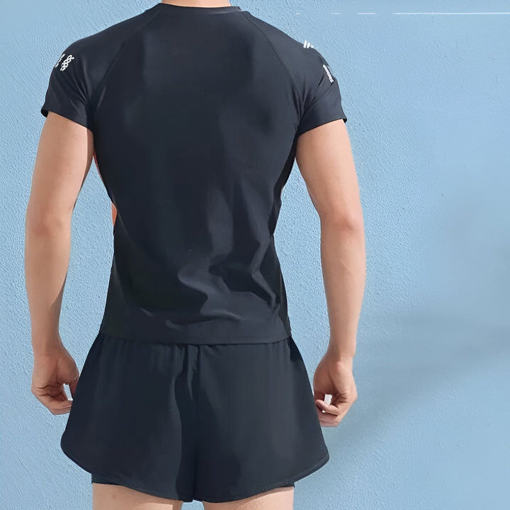 Short de course noir pour homme, avec doublure intérieure, bandes orange et blanches sur le côté, idéal pour le sport et l'exercice.