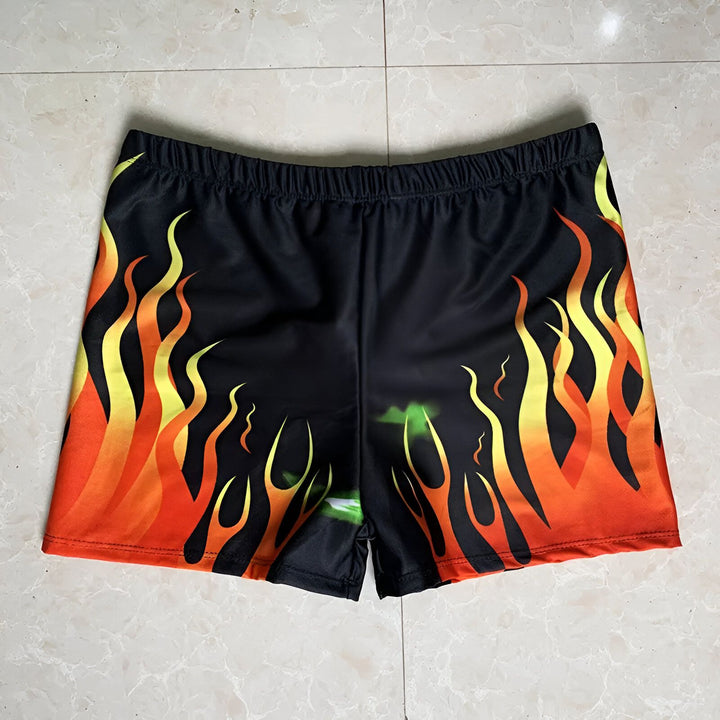 Short de bain noir orné de motifs de flammes orange, jaunes et rouges. Idéal pour la plage ou la piscine. Design audacieux et tendance.
