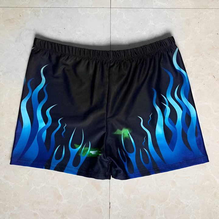 Slip de bain bleu marine avec des motifs de flammes bleues et des accents verts, idéal pour la natation.