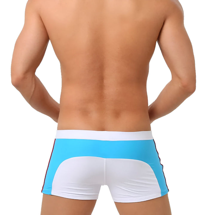 Dos d'un homme portant un caleçon de bain blanc et bleu. Vêtement de bain pour homme. Maillot de bain masculin de sport.