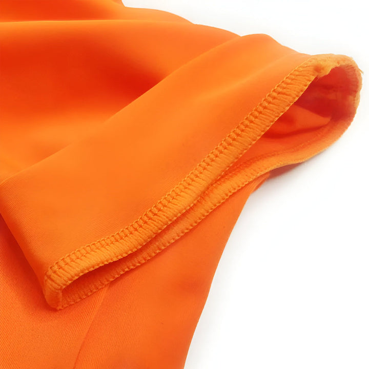 Gros plan d'un vêtement orange, mettant en évidence la texture lisse du tissu et la finition ourlée soignée, idéal pour la mode et le design textile.