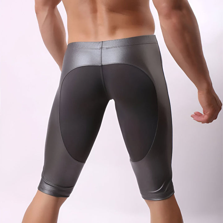 Vue arrière d'un homme portant un collant de sport gris et noir. Ses muscles du dos sont visibles.