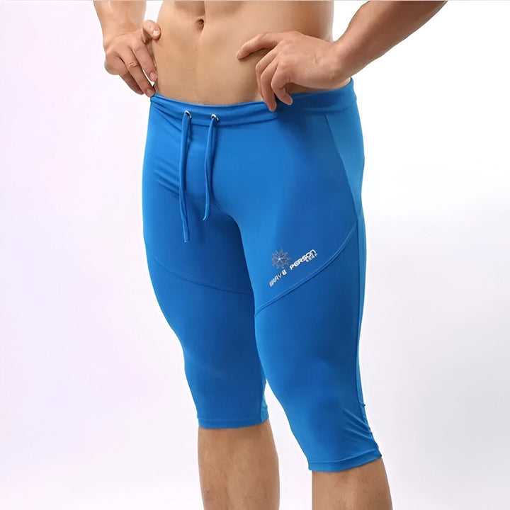 Homme vu de dos, portant un legging de sport vert olive trois-quarts. Vêtements d'entraînement masculins, athlétisme, mode sportive pour hommes.