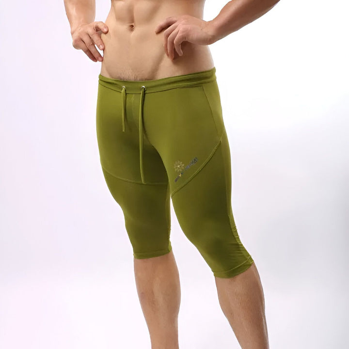 Homme portant un legging de sport bleu. Vêtement de compression athlétique moulant le corps, visible de côté. Idéal pour l'entraînement, le fitness ou la course.