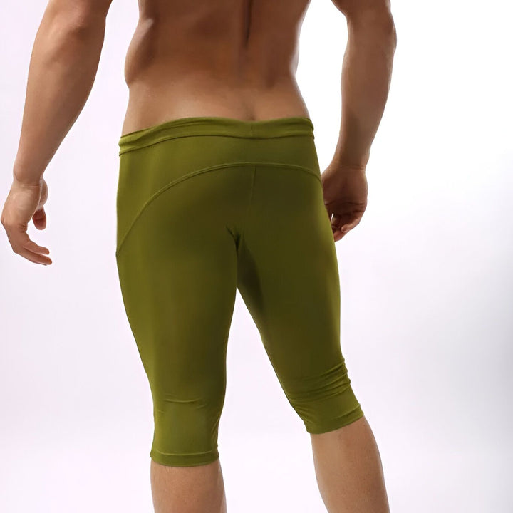 Homme en pantalon de sport bleu serré. Vêtement athlétique moulant, idéal pour l'entraînement. Design moderne avec cordon à la taille et logo discret.