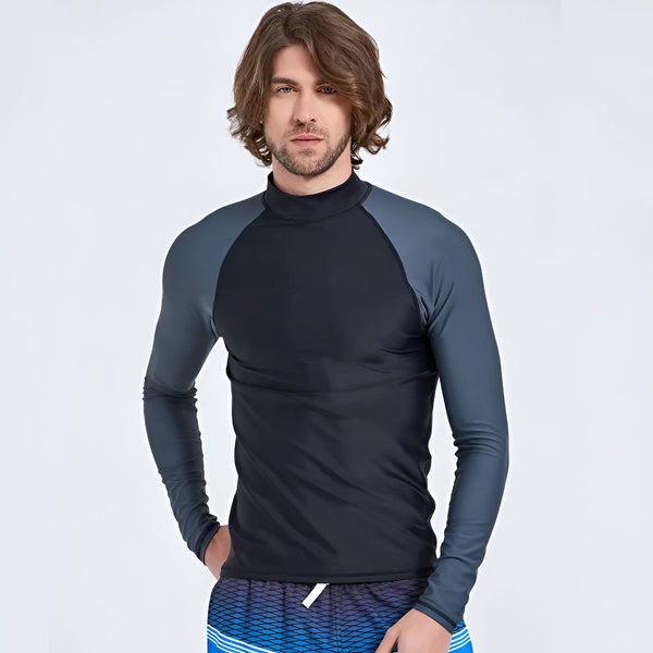 Homme portant un rashguard de surf noir et gris à manches longues avec un short de bain bleu à rayures. Vue de dos.