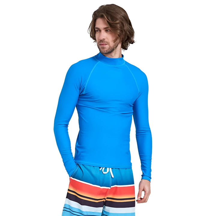 Homme portant un rashguard noir et gris avec un short de bain bleu à rayures. Vêtement de protection solaire pour sports nautiques. Style et protection UV.