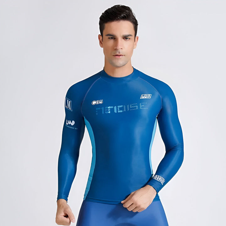 Homme en combinaison de surf bleue à manches longues et short de bain assorti, regardant vers le bas. Vêtements de sport aquatiques avec logos et détails modernes. Style et protection pour les sports nautiques.