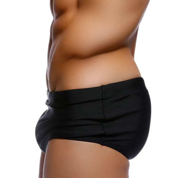 Gros plan sur le tissu noir texturé d'un vêtement de contention ou de lingerie sculptante. Détails des coutures et de la matière gainante.